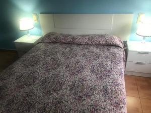 - un lit dans une chambre d'hôtel avec 2 tables de nuit dans l'établissement Apartamento avenida, à Elche de la Sierra