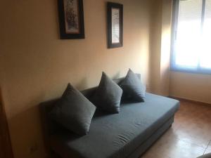 a blue couch with pillows on it in a room at Apartamento avenida in Elche de la Sierra