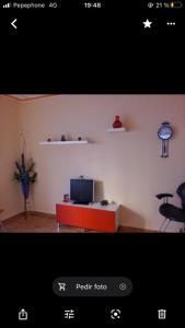 a living room with a television and a red cabinet at Apartamento avenida in Elche de la Sierra