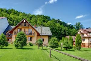 una casa grande con un patio verde con árboles en Wynajem pokoi Natalia, en Sromowce Niżne