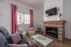 a living room with a fireplace and a tv at Casa Rural Rafael Lantejuela in La Lantejuela