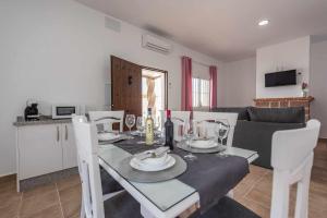 - une salle à manger et une cuisine avec une table et des chaises dans l'établissement Casa Rural Rafael Lantejuela, à La Lantejuela