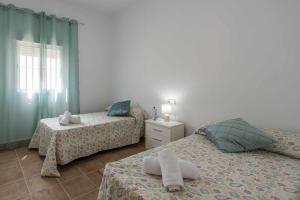 two beds with towels on them in a bedroom at Casa Rural Rafael Lantejuela in La Lantejuela +41 photos
