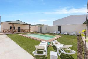 une cour avec une piscine, des chaises et une piscine dans l'établissement Casa Rural Rafael Lantejuela, à La Lantejuela