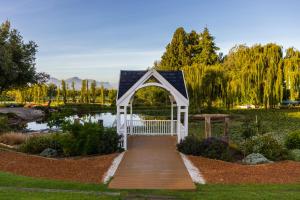 a white gazebo in a garden with a pond at Lord Charles Hotel in Somerset West