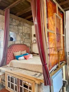 ein Schlafzimmer mit einem Bett in einer Steinmauer in der Unterkunft Vintage House near São Pedro do Sul in Fataunços