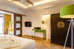 a bedroom with a bed and a green lamp at Salvator Villas & Spa Hotel in Parga
