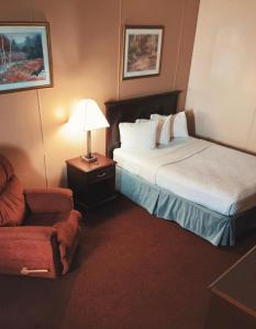 una camera d'albergo con due letti e una sedia di FairBridge Inn & Suites Williston a Williston