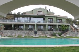 a large building with a pool in front of it at Belizi Hotel in Urla