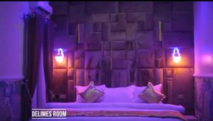 a purple bedroom with a bed with pillows and lights at Delimes Hotel in Use
