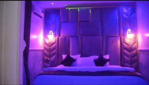 a purple bedroom with a bed with pillows and lights at Delimes Hotel in Use