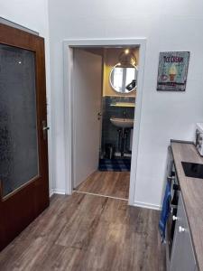 a room with a hallway with a door and a kitchen at Ferienwohnung am MeetingPoint in Weilmünster