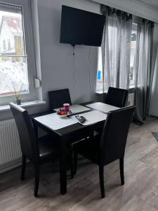 a dining room table with two chairs and a black table and chairsktop at Ferienwohnung am MeetingPoint in Weilmünster