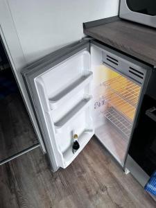 an empty refrigerator with its door open in a kitchen at Ferienwohnung am MeetingPoint in Weilmünster