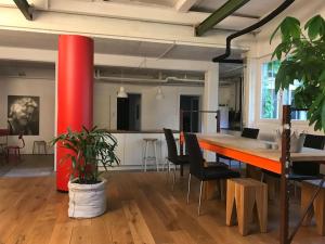 um escritório com uma mesa e cadeiras e uma coluna vermelha em Loft63 am Bodensee em Arbon