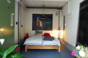 a bedroom with a bed with a painting on the wall at Loft63 am Bodensee in Arbon
