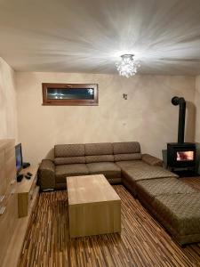 sala de estar con sofá y chimenea en Ubytovanie Žaneta, en Krásnohorské Podhradie