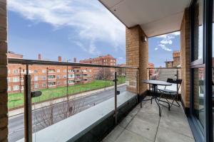 a balcony with a table and a view of a street at Immaculate 3BR apt in Hackney in London