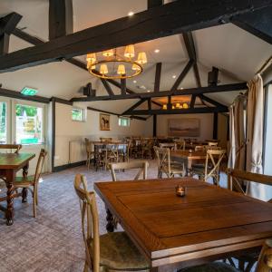 comedor con mesas y sillas de madera en High Corner Inn, en Ringwood