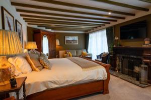 a bedroom with a large bed and a fireplace at High Corner Inn in Ringwood