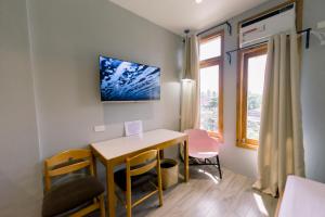 ein kleines Zimmer mit einem Tisch, Stühlen und einem Fenster in der Unterkunft Madonna Hometel and Suites New Pandan in Panabo