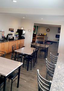 uma sala de jantar com mesas e cadeiras e uma cozinha em FairBridge Inn & Suites Williston em Williston