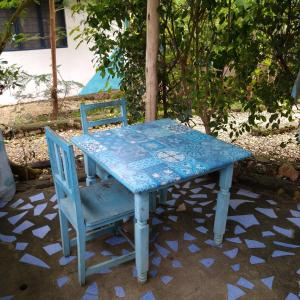 een blauwe tafel en 2 stoelen op een patio bij Furaha B&B Kendwa in Kendwa