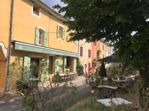 eine Straße mit Tischen und Stühlen vor einem Gebäude in der Unterkunft Hôtel Restaurant L’Observatoire in Saint-Michel-lʼObservatoire