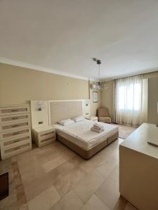 a large bedroom with a large bed and a dresser at Alanya gold city hotel main building 3 bedroom apartment in Alanya