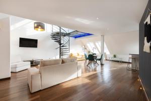 una sala de estar con muebles blancos y una escalera. en Le Loft Du Gibet en Montigny-lès-Metz