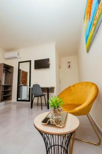 a living room with a table and a yellow chair at Greenshade Lodge in Johannesburg