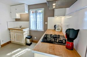 a kitchen with a stove and a counter top at Le Cocon des Hautes-Côtes in Fussey