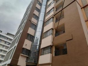 een hoog appartementencomplex met een brandtrap bij Cosy One bedroom Thika Road,TRM in Nairobi
