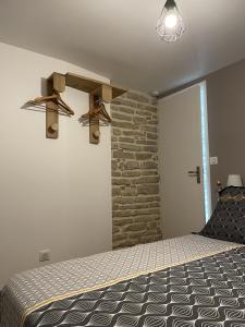 a bedroom with a bed and a stone wall at Le Cocon des Hautes-Côtes in Fussey