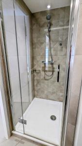 a shower with a glass door in a bathroom at Le Cocon des Hautes-Côtes in Fussey +9 photos
