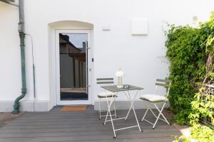 een patio met een tafel en 2 stoelen op een veranda bij DWELLSTAY - Apartment mit eigenem Eingang I 30qm I zentrale Lage I Bad I Küche I Terrasse I TV in Fulda