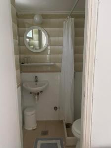 een kleine badkamer met een wastafel en een spiegel bij Korali Hotel in Antiparos Stad