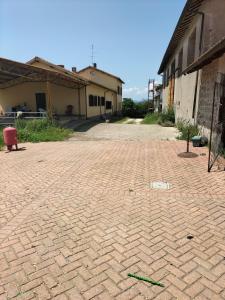 un aparcamiento de ladrillo vacío con un edificio en el fondo en Rod Ranch Livestock- Stanza matrimoniale, en Campagnano di Roma