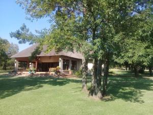 a house with a tree in front of it at Gentleman's Estate on the Vaal River in Vanderbijlpark