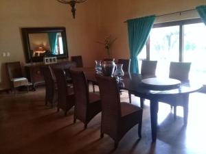 a dining room with a table and chairs and a mirror at Gentleman's Estate on the Vaal River in Vanderbijlpark