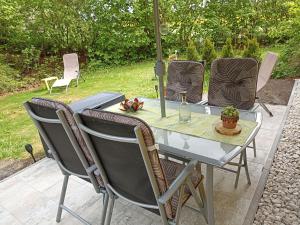 a table with four chairs and a bottle of wine at Ferienwohnung NatuRaum in Gräfenberg