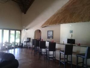 a room with a bar with chairs and a table at Gentleman's Estate on the Vaal River in Vanderbijlpark