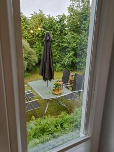 una mesa con sombrilla y sillas en el patio en Ferienwohnung NatuRaum en Gräfenberg