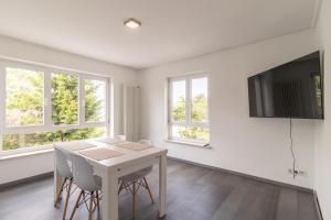 a dining room with a table and chairs and windows at Unique: Geräumige 4 Zimmerwohnung in Tuttlingen mit Sauna, Fitness und Netflix OG in Tuttlingen