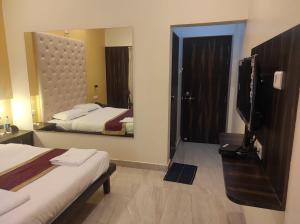Katil atau katil-katil dalam bilik di Hotel Deepak Executive, Ganpatipule