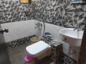 a small bathroom with a sink and a toilet at Hotel Deepak Executive, Ganpatipule in Ganpatipule