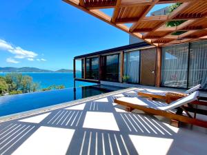 a house with a deck with a view of the water at The Naka Phuket, a Member of Design Hotels - SHA Extra Plus in Kamala Beach