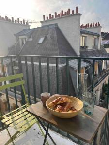 een kom eten op een houten tafel op een balkon bij Superbe appartement entièrement rénové in Parijs