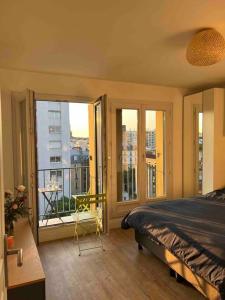 1 dormitorio con 1 cama y balcón con vistas. en Superbe appartement entièrement rénové, en París