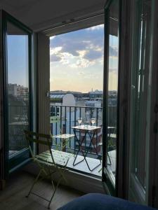 een kamer met een balkon met een stoel en een tafel bij Superbe appartement entièrement rénové in Parijs